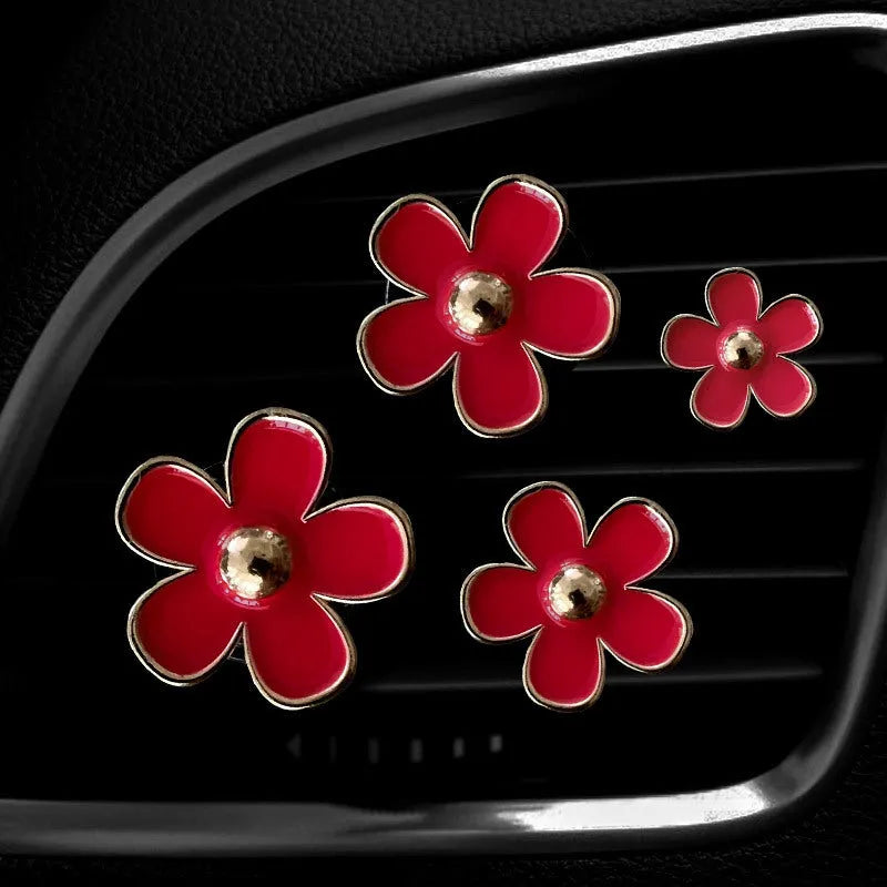 Set of four metal flower-shaped car vent aromatherapy clips in assorted colours