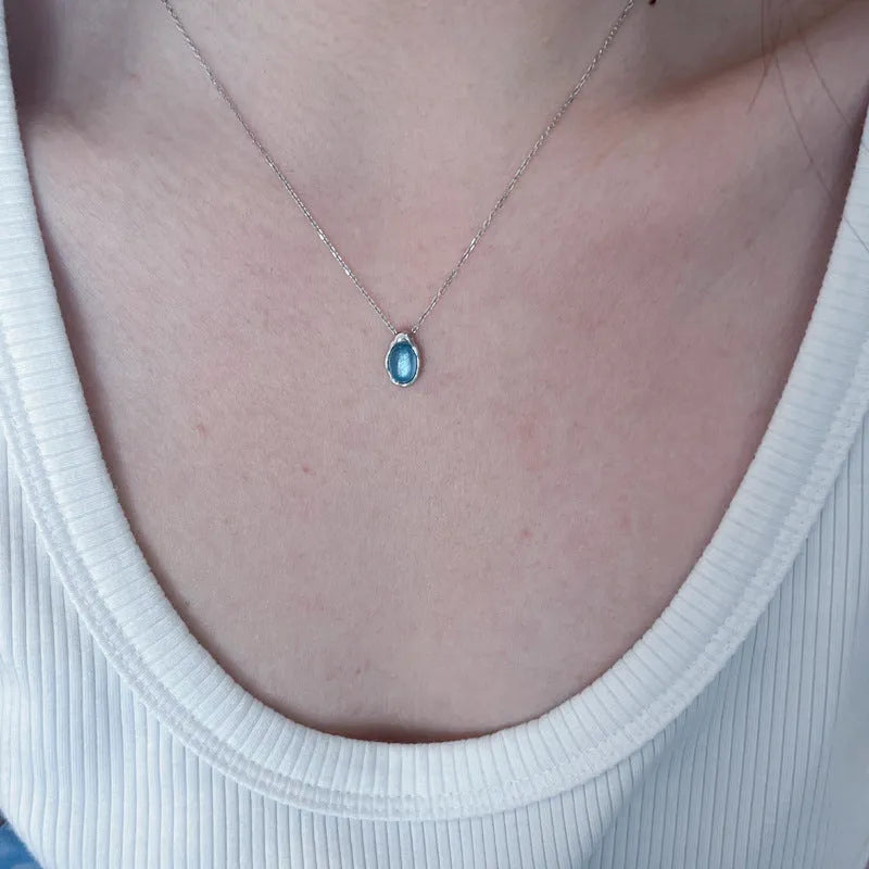 Women's navy blue geometric water drop pendant necklace on an adjustable copper chain.