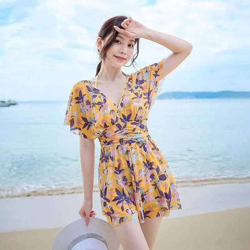 Yellow floral print women's one-piece swimsuit on hanger showing front design
