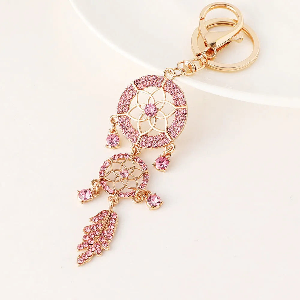 Creative diamond studded flower shaped car keychain dream catcher in pink alloy light luxury style on white background