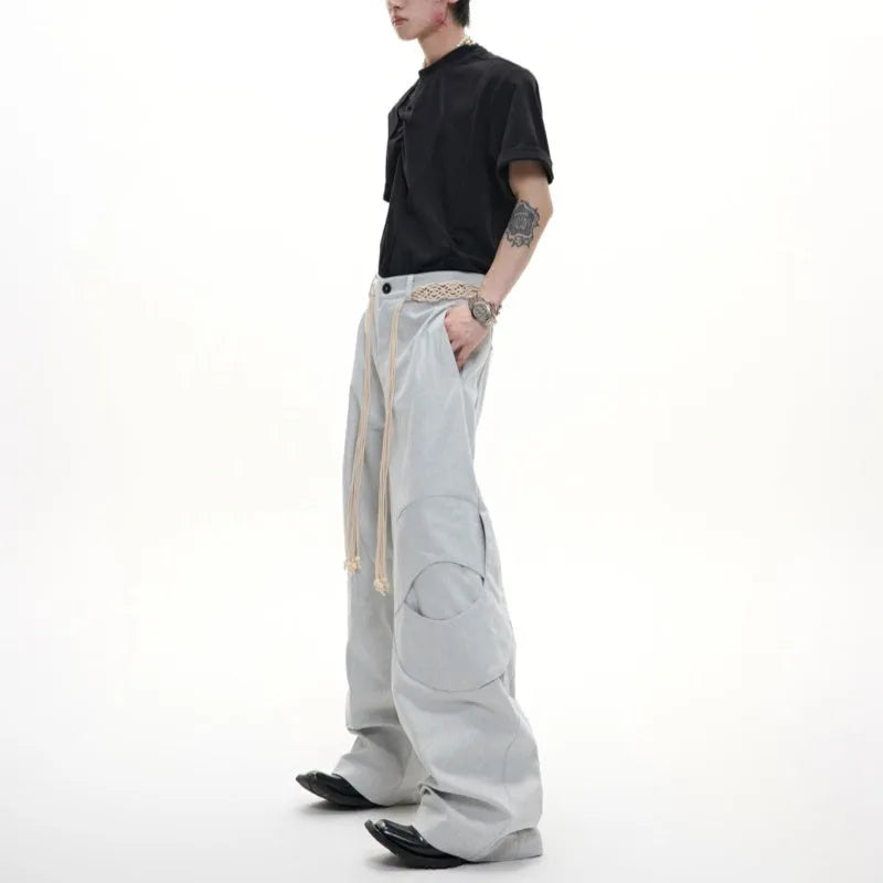 Man wearing dark blue loose-fit straight-leg cotton jeans with zip decoration and belt stitching.