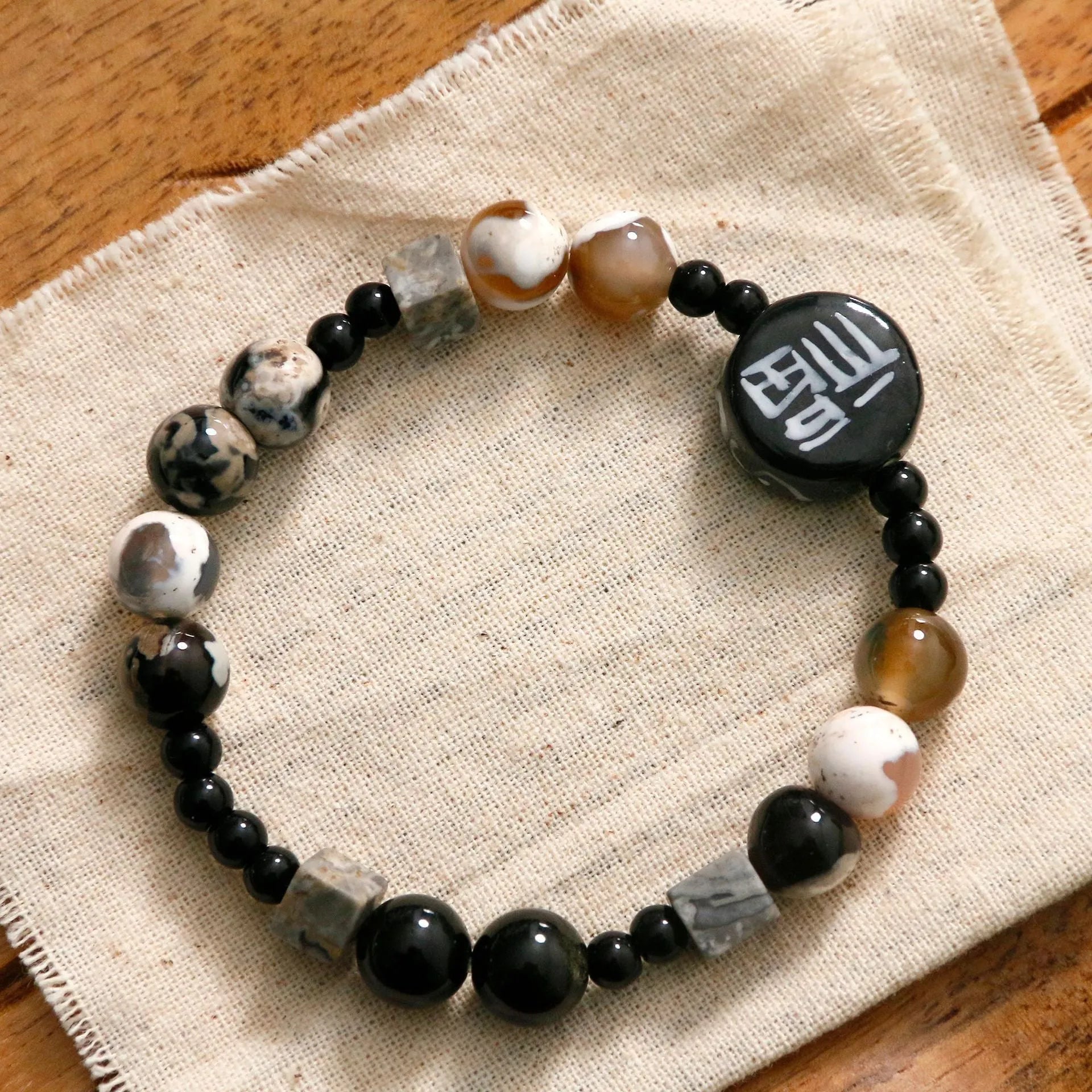 Hand-woven natural black agate and ceramic bracelet with geometric round bead design