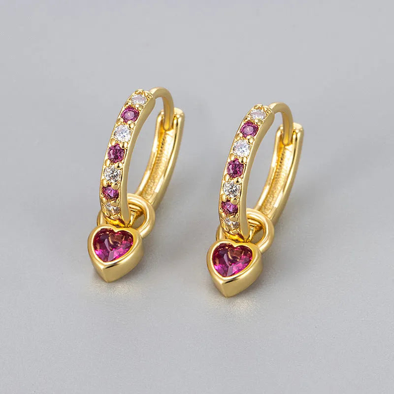 Gold colour heart-shaped clip earring with a central blue zircon stone on a white background.