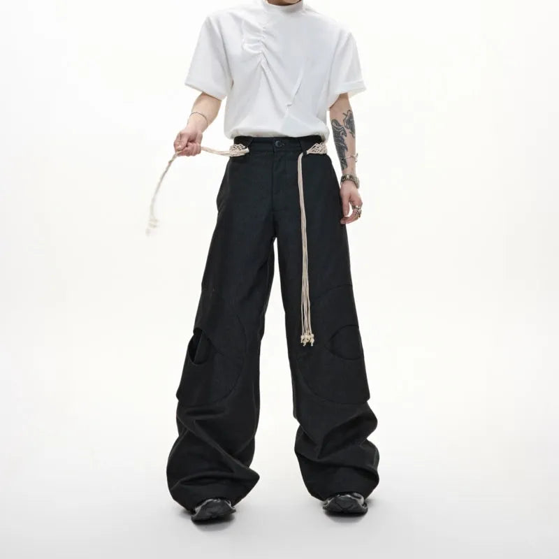 Man wearing dark blue loose-fit straight-leg cotton jeans with zip decoration and belt stitching.