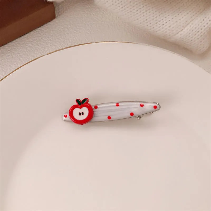 Red love heart-shaped plastic hair clip with retro dots and a willow leaf silhouette on a white background.