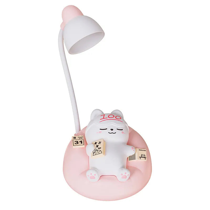 Sleeping cat shaped small night lamp in pink with USB charging cable on bedside table