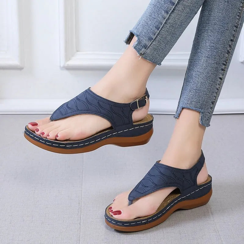 Women's solid colour wedge heel flip flop sandals with an adjustable buckle strap.