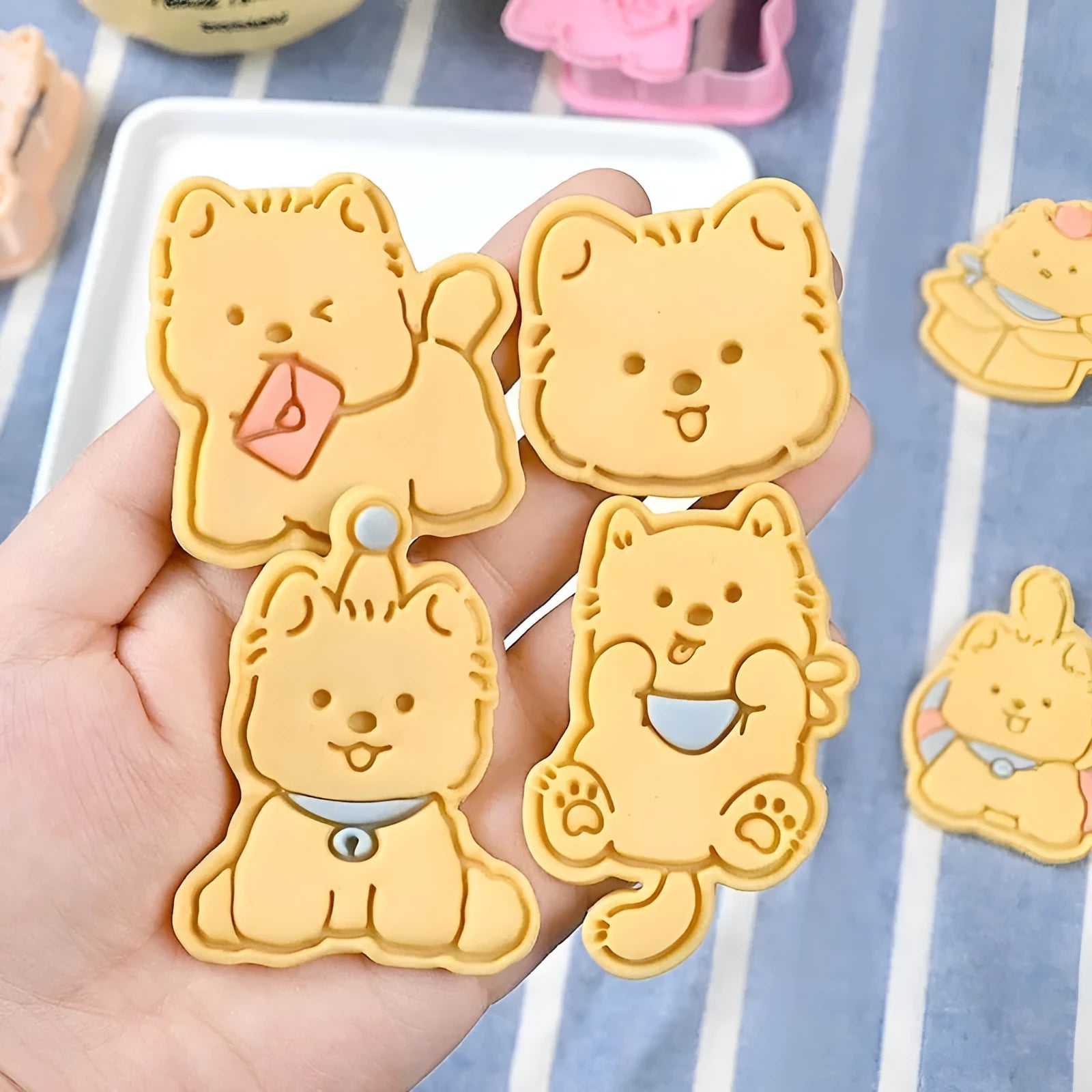 A 3D plastic biscuit mould showing raised puppy head, birthday hat, and dog cartoon designs.