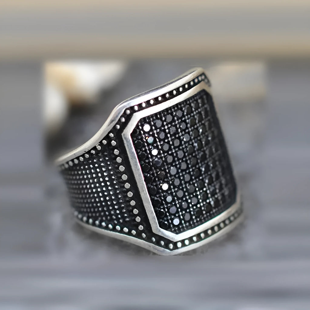 Black alloy ring with copper inlaid zircon detailing showing metallic finish