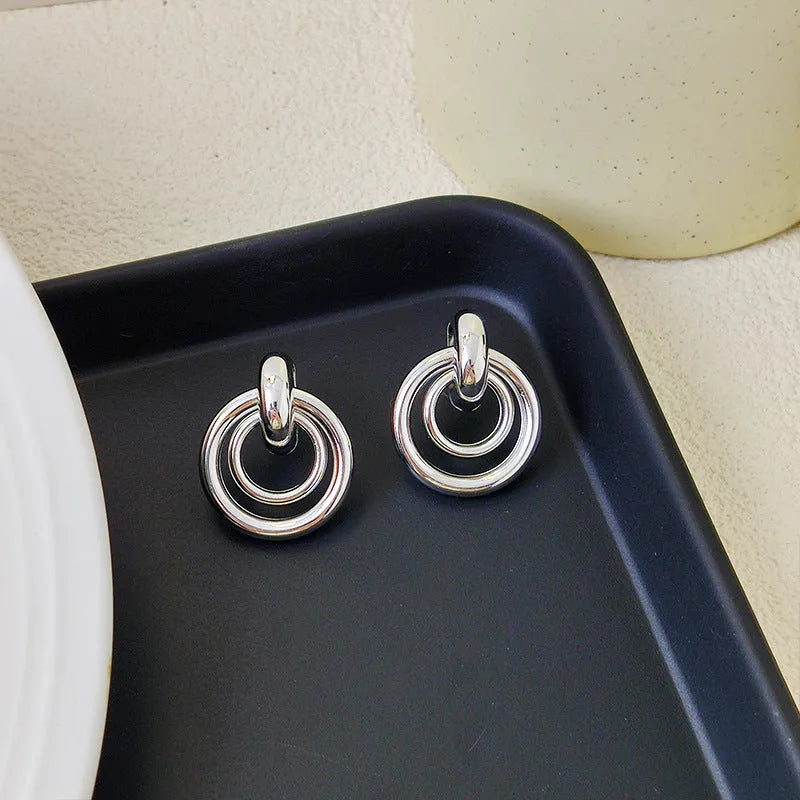 A pair of women's geometric round ring earrings with an irregular shape in a gold electroplated finish.