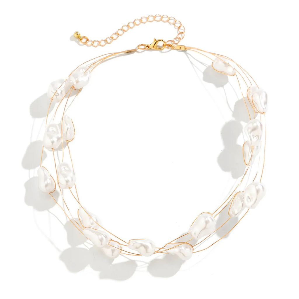 Gold-tone baroque imitation pearl necklace and bracelet set with U-shaped pendant on woman