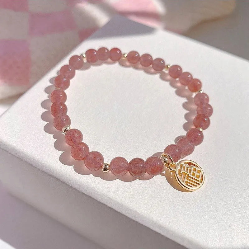 A New Chinese style glass bracelet with strawberry quartz stones and a blessing card.