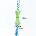 Green porous bone-shaped dog toy with rope knot texture and slots for beef strips or cheese treats