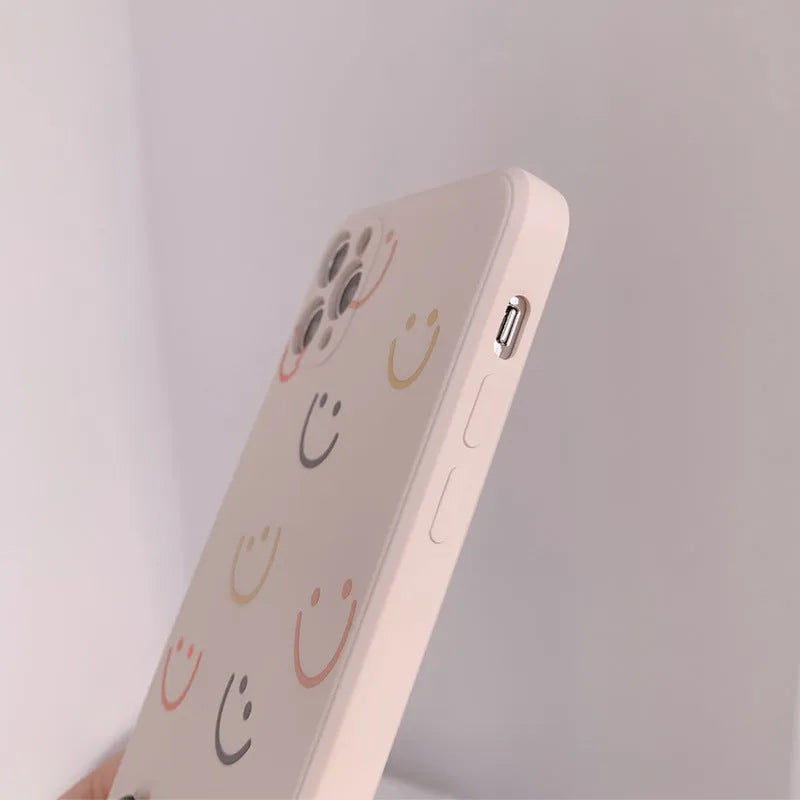 Simple TPU silicone iPhone case with painted smiley face and graffiti design on a table
