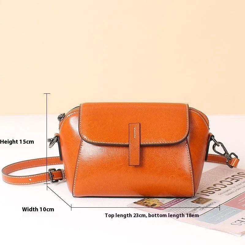 Brown oil wax leather women's messenger bag with cross-body strap showing shell shape and interior compartments