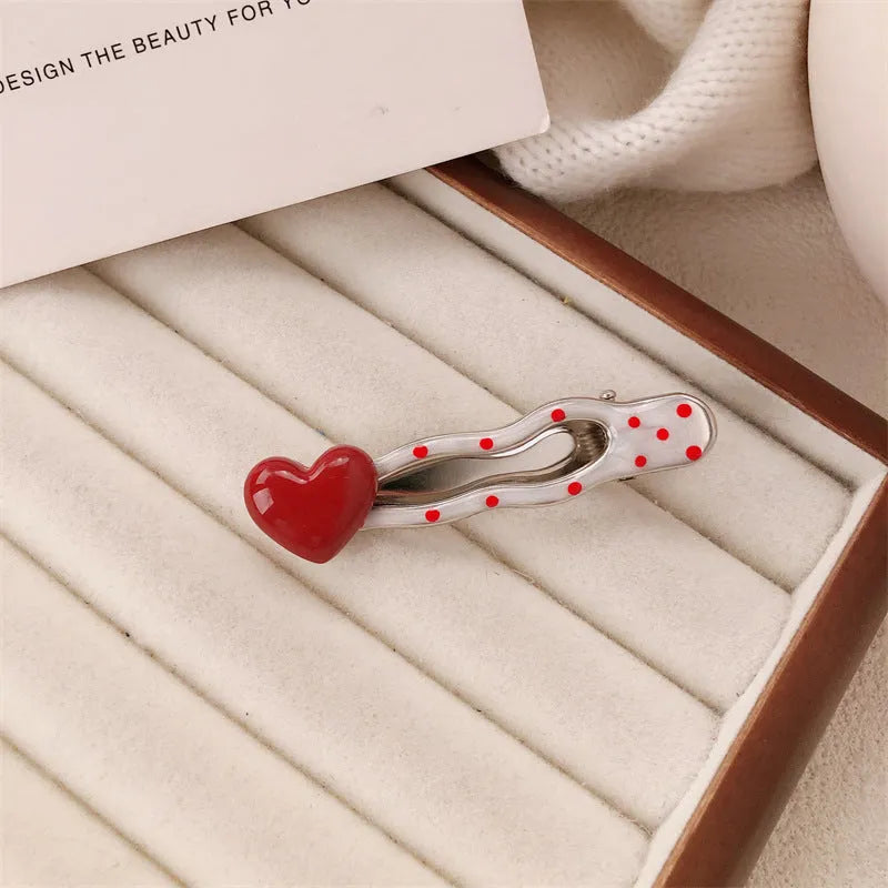 Red love heart-shaped plastic hair clip with retro dots and a willow leaf silhouette on a white background.