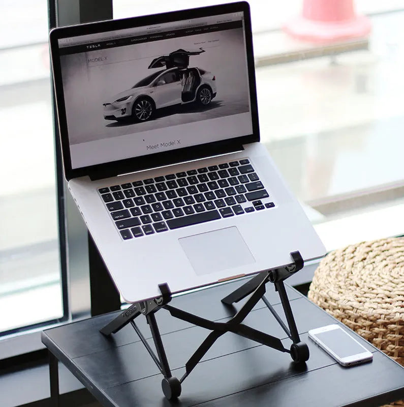Sagacious black foldable laptop stand with enhanced nylon construction on desk