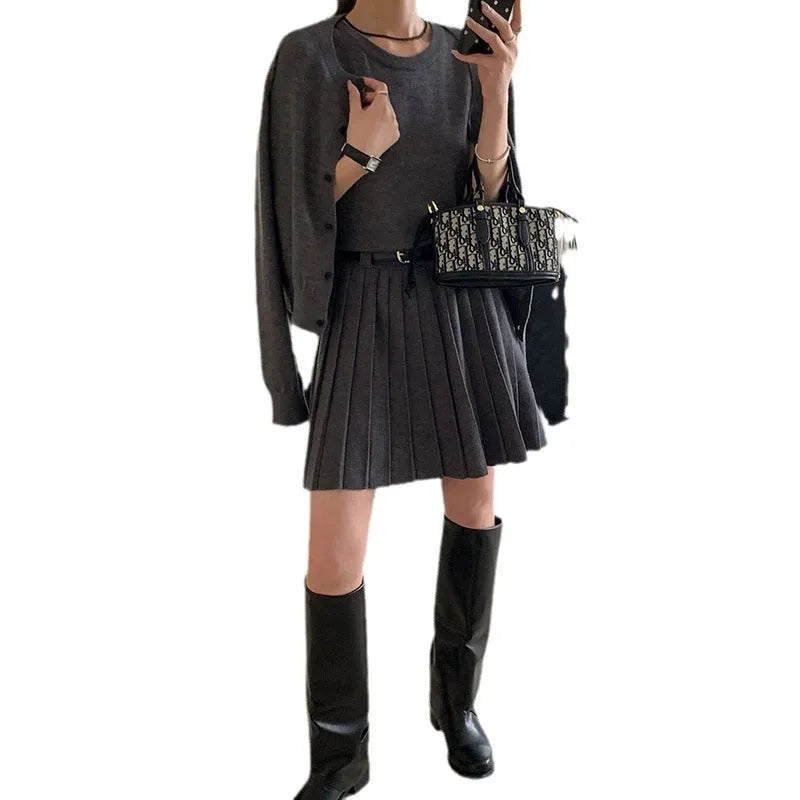 Grey knitted women's two-piece set with a pleated vest skirt and long-sleeved cardigan.