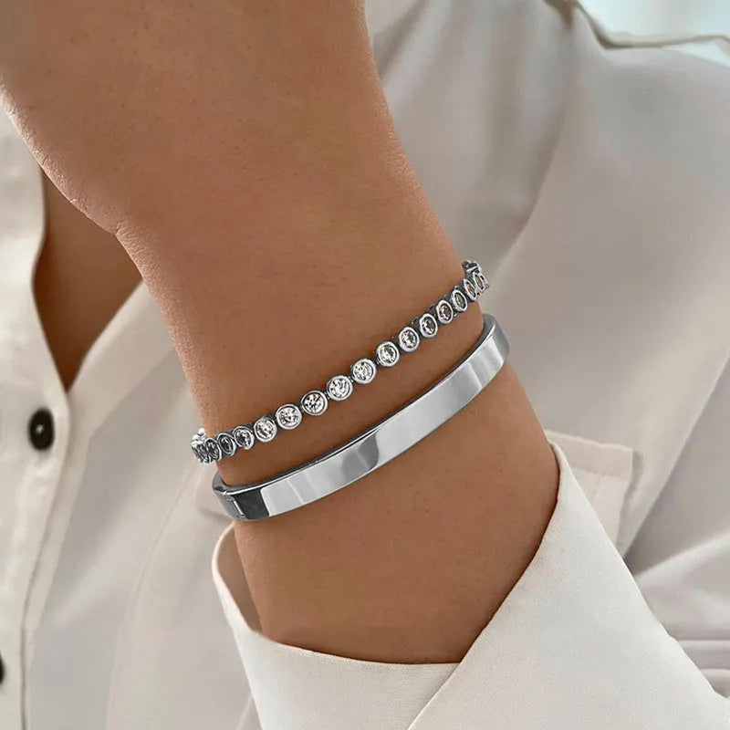 Two vintage drop-shaped geometric bracelets in gold and silver, side by side