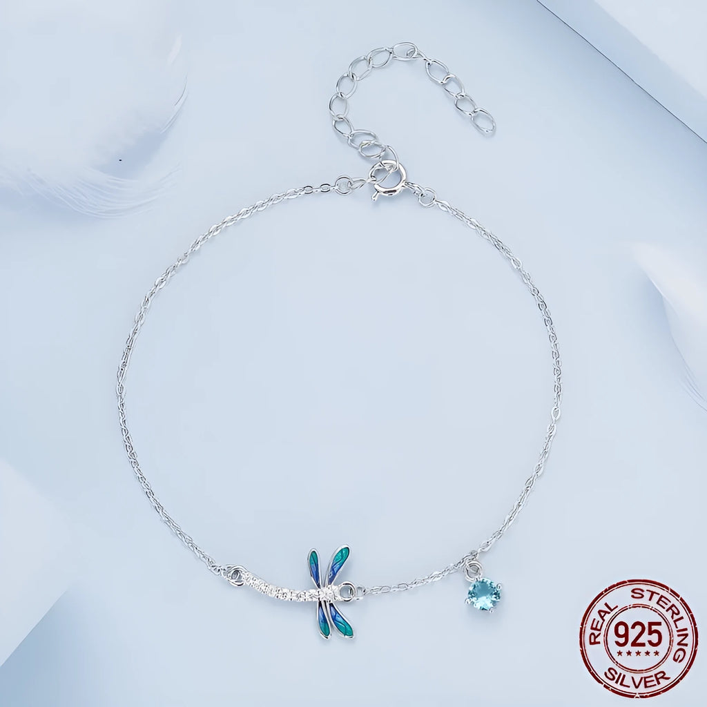 Sterling silver white gold plated dragonfly bracelet with dripping zircon stones on white background
