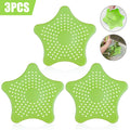 Three starfish-shaped TPR sink drain filters in blue, green, and white on a bathroom sink