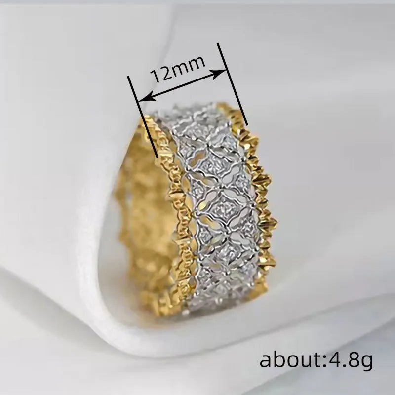 Geometric two-tone gold zircon ring on a plain background showing its round centrepiece and band detail