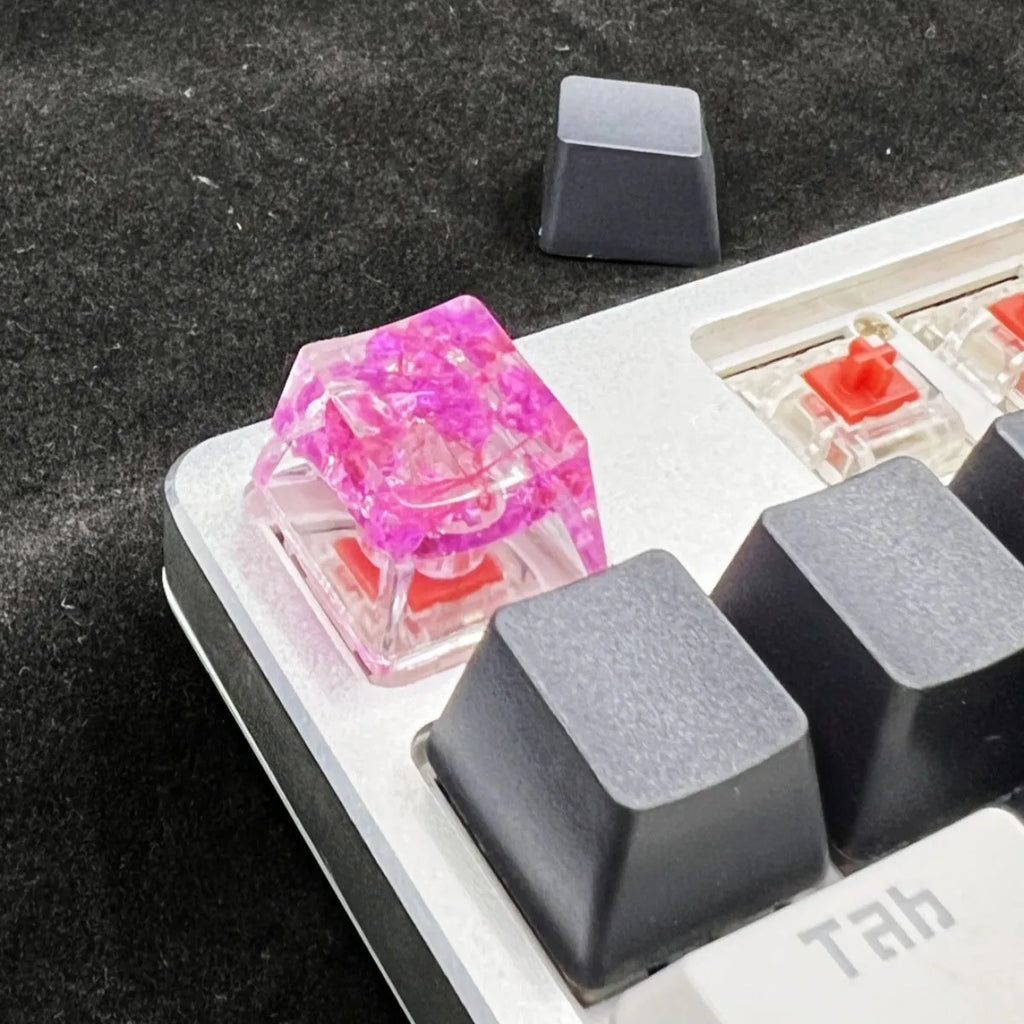 Transparent resin mechanical keyboard keycap with starry sky pattern in red, pink, green, and violet colour options