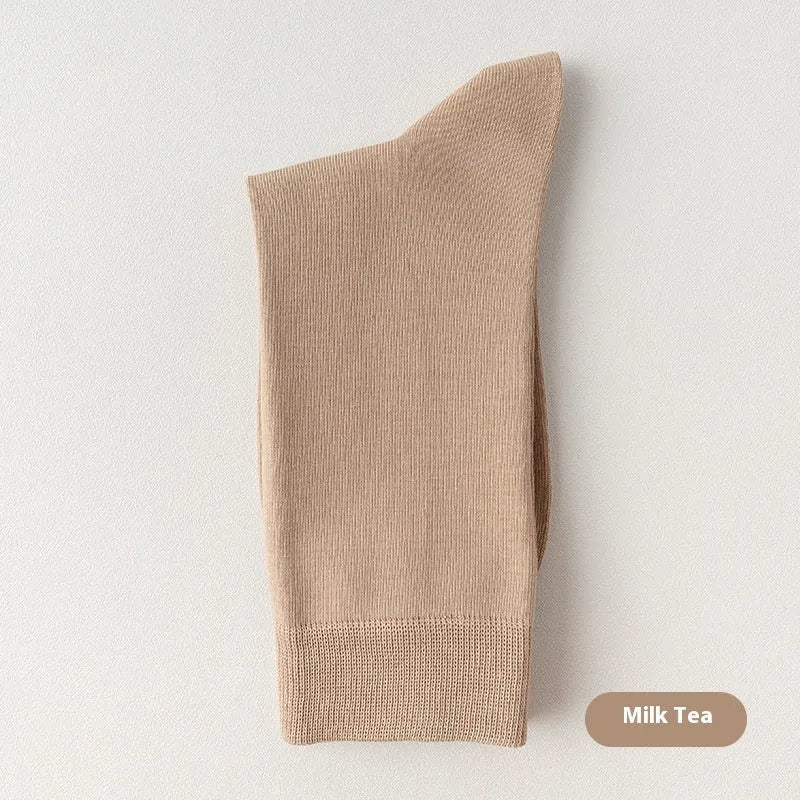 Five pairs of men's solid colour mid-calf socks made from combed cotton, shown in assorted shades.