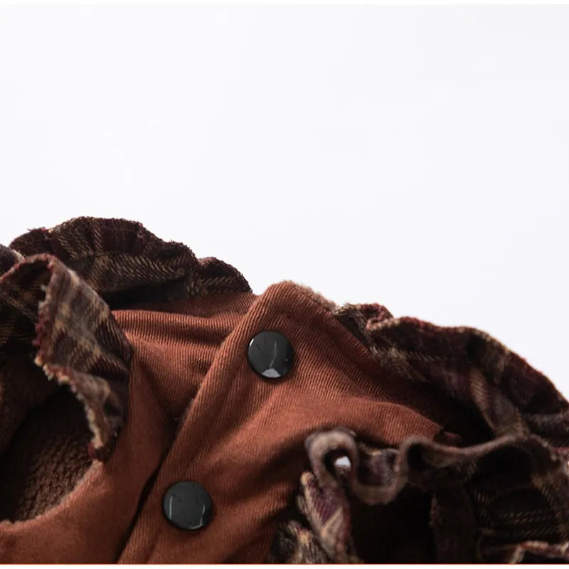 Fleece-lined brown plaid pet sweater dress with ruffle trim on a small dog, showing stretchable knit and skirt silhouette