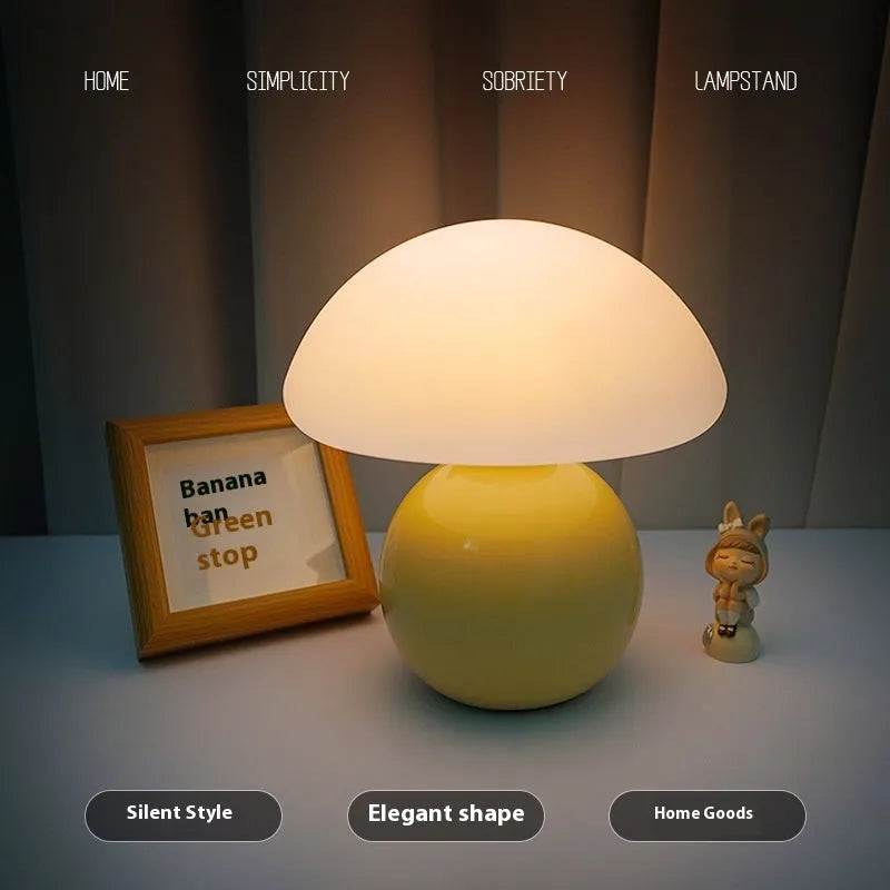 Cream ceramic mushroom table lamp with USB power cord on a bedside table, available in yellow