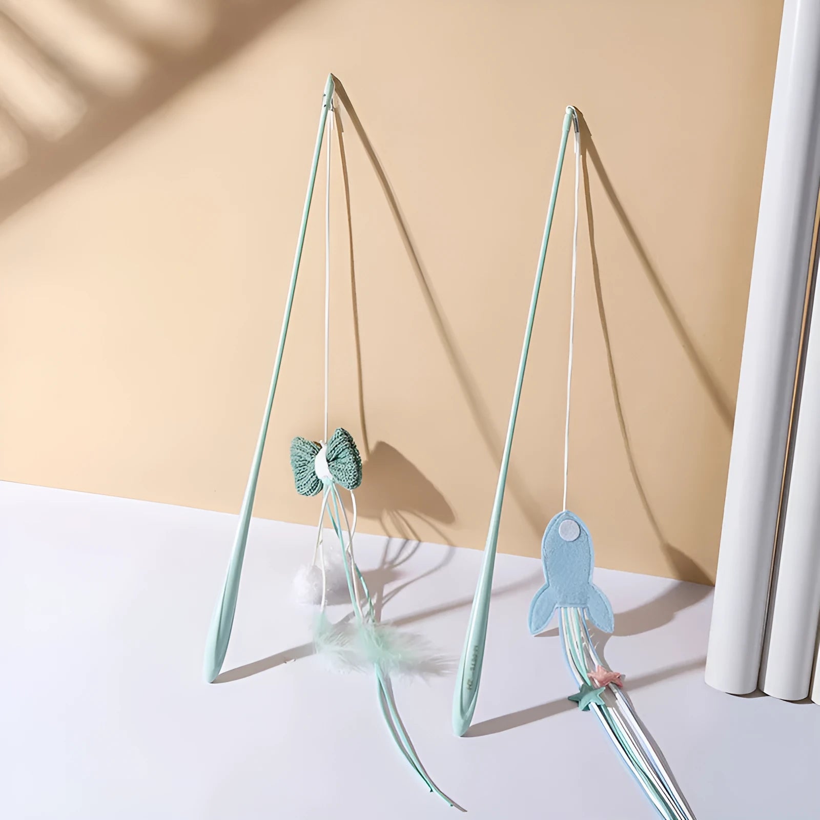 Adjustable cat teaser wand with telescopic pole extended to show feather attachments and inflatable ego component