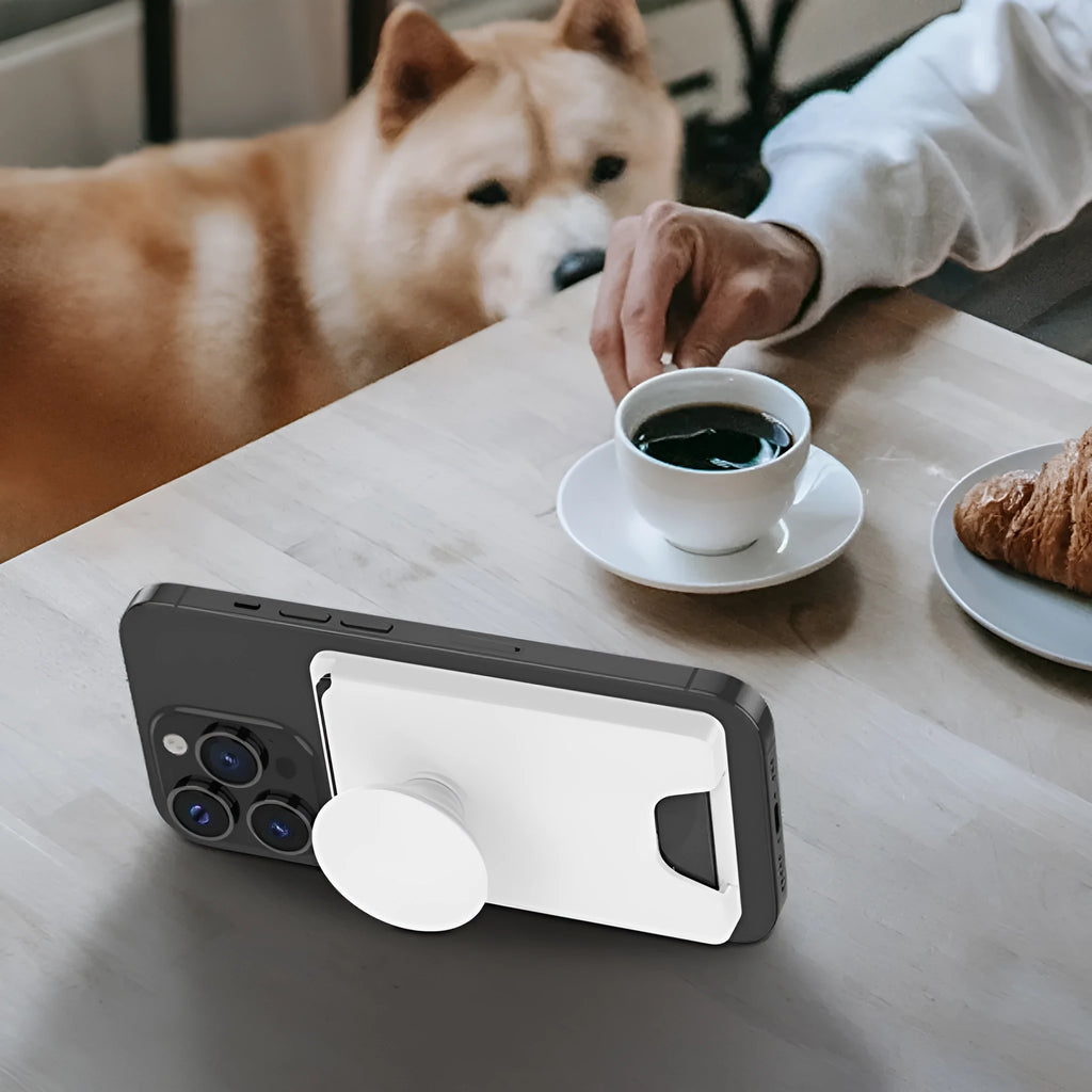 Minimalist black magnetic suction phone holder for iPhone on a desk.