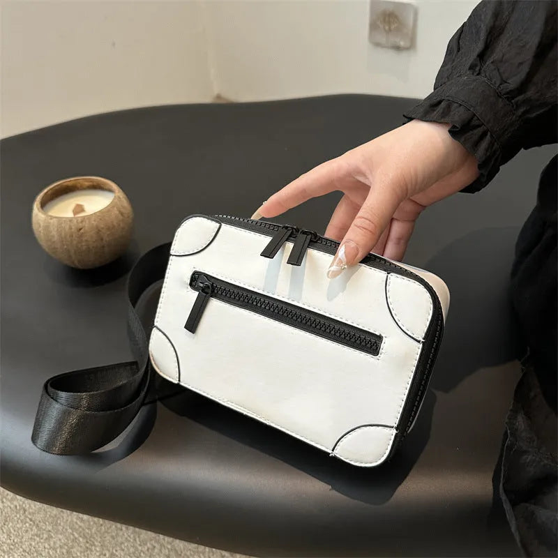 Women's black square crossbody bag showing internal mobile phone pocket and adjustable shoulder strap