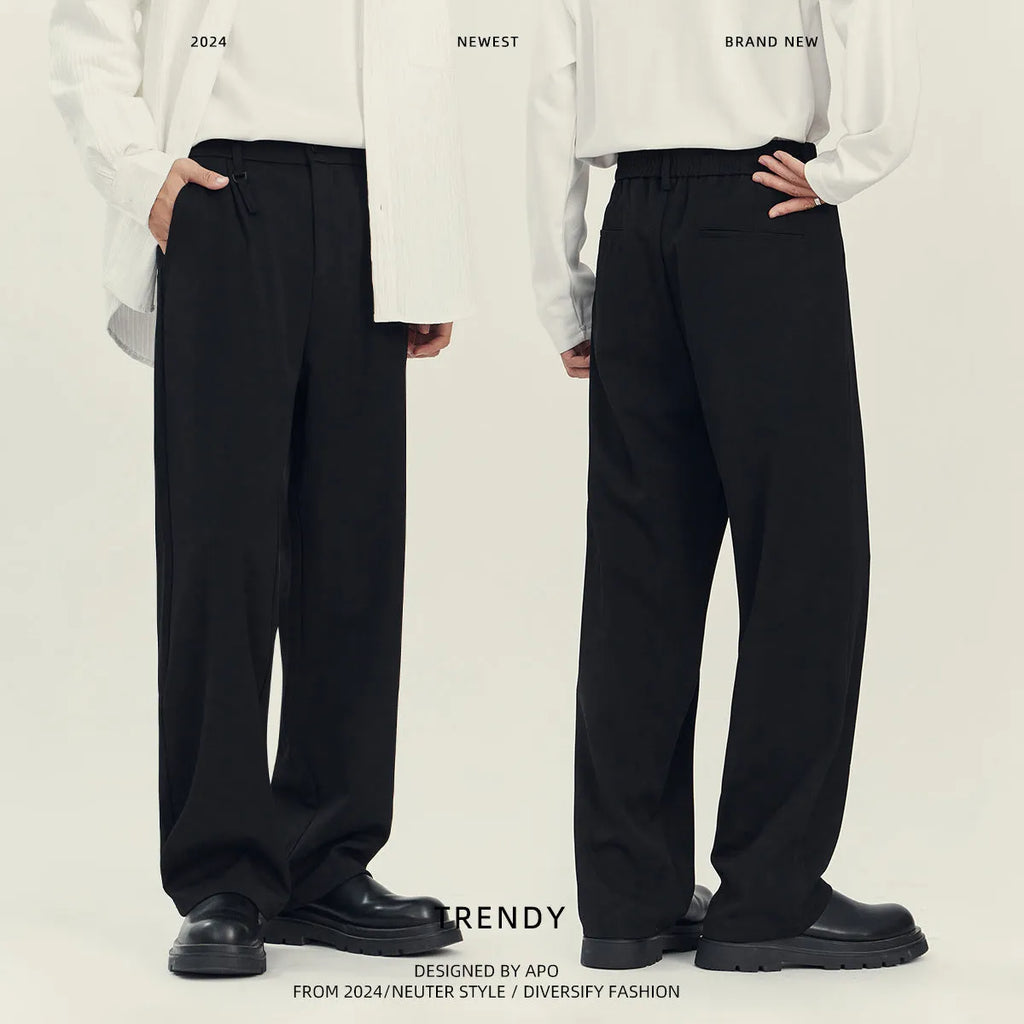Men's black loose straight-leg business casual trousers on a hanger showing the draping style fit.