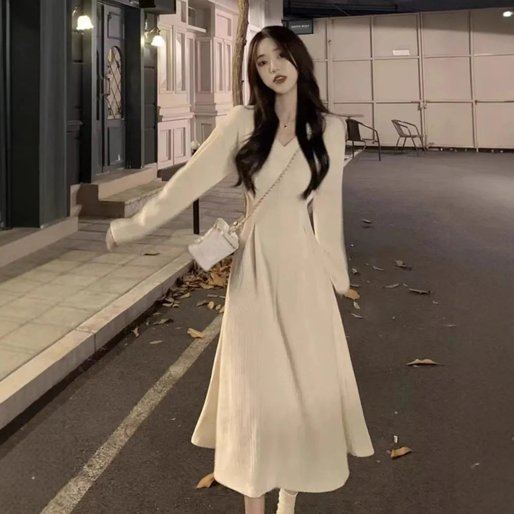 Women's white V-neck knitted dress with princess sleeves and a suspender skirt design.