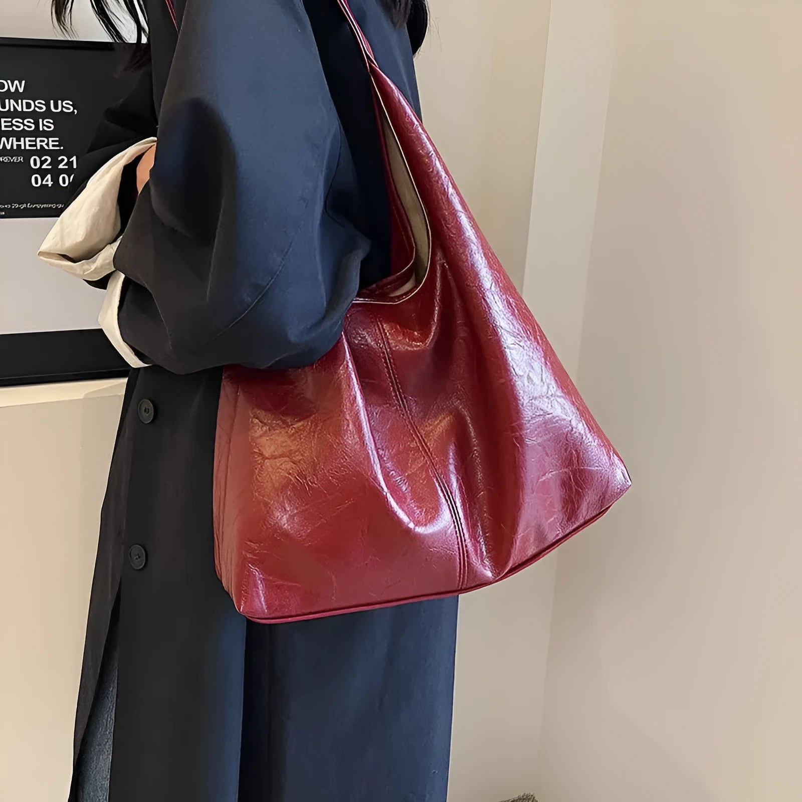 Soft black PU leather shoulder bag with large compartment and adjustable strap on a plain background.