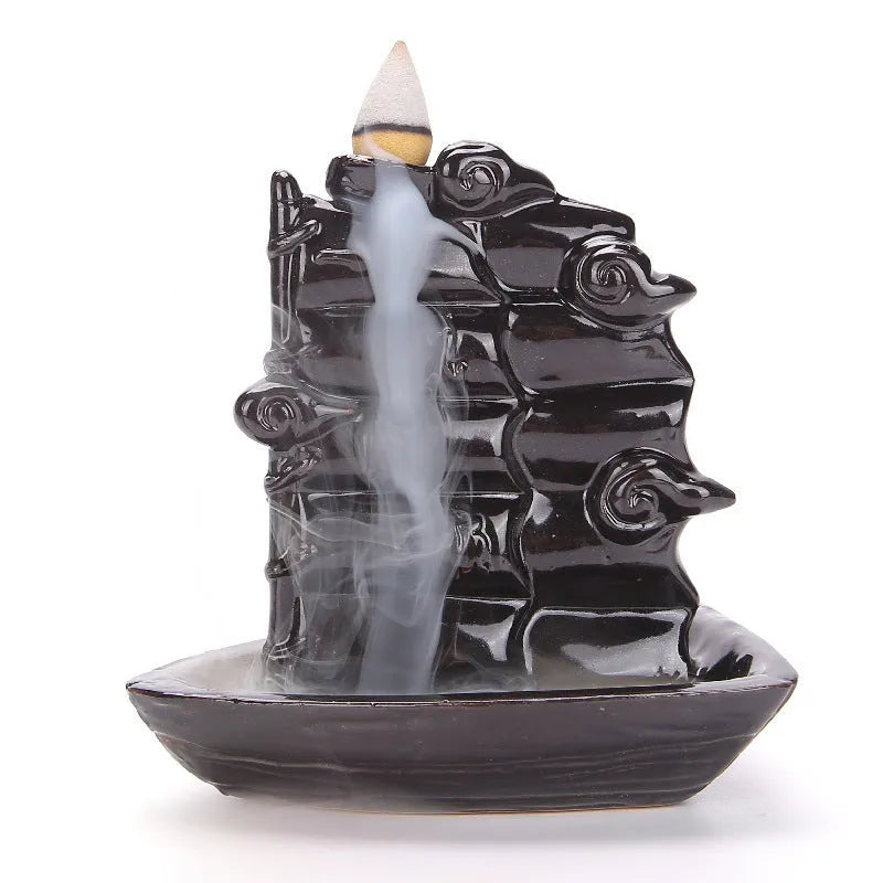 Ceramic backflow incense burner ornament in modern tree design on a table.