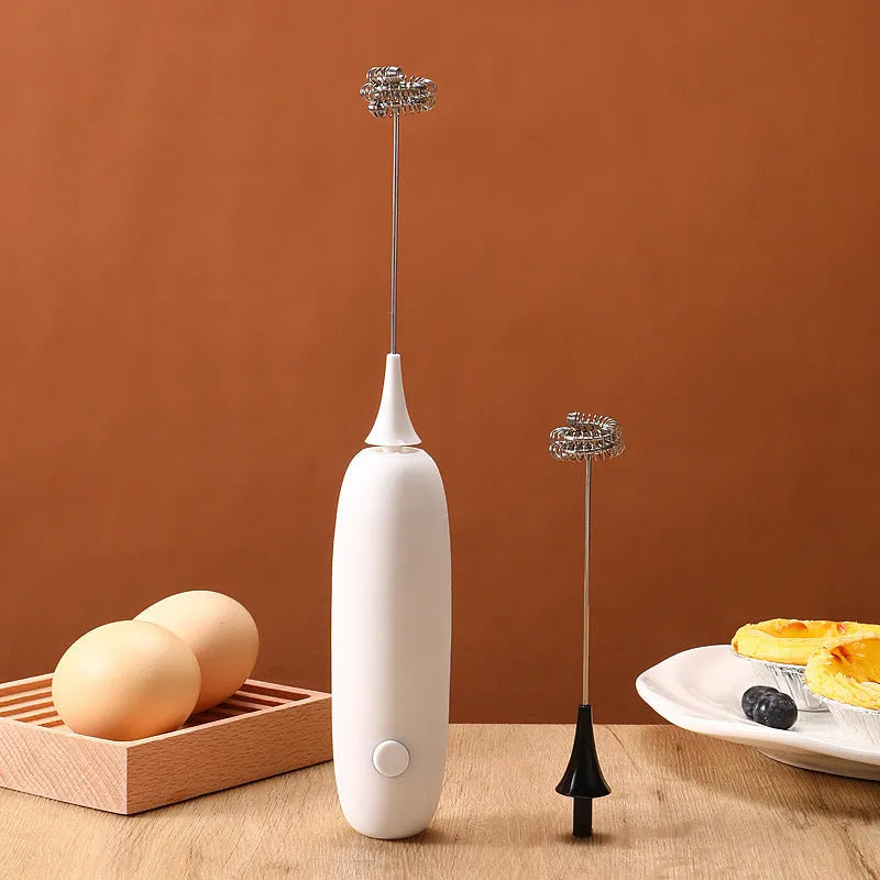 Black and white electric hand-held milk frother and blender for coffee beverages