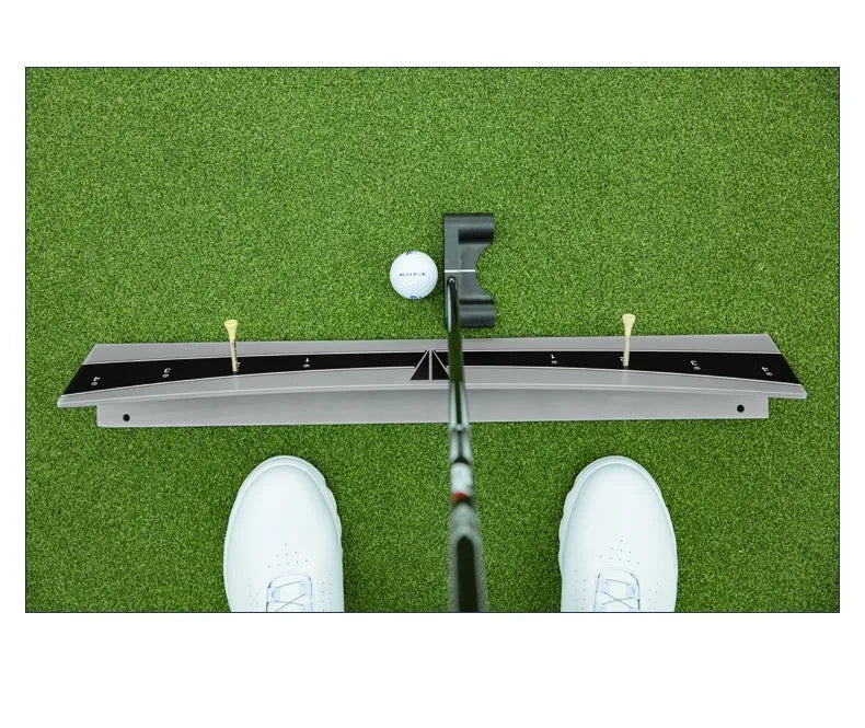 A white PVC golf putter trajectory balance simulator with an adjustable push rod balancer on a grey surface.
