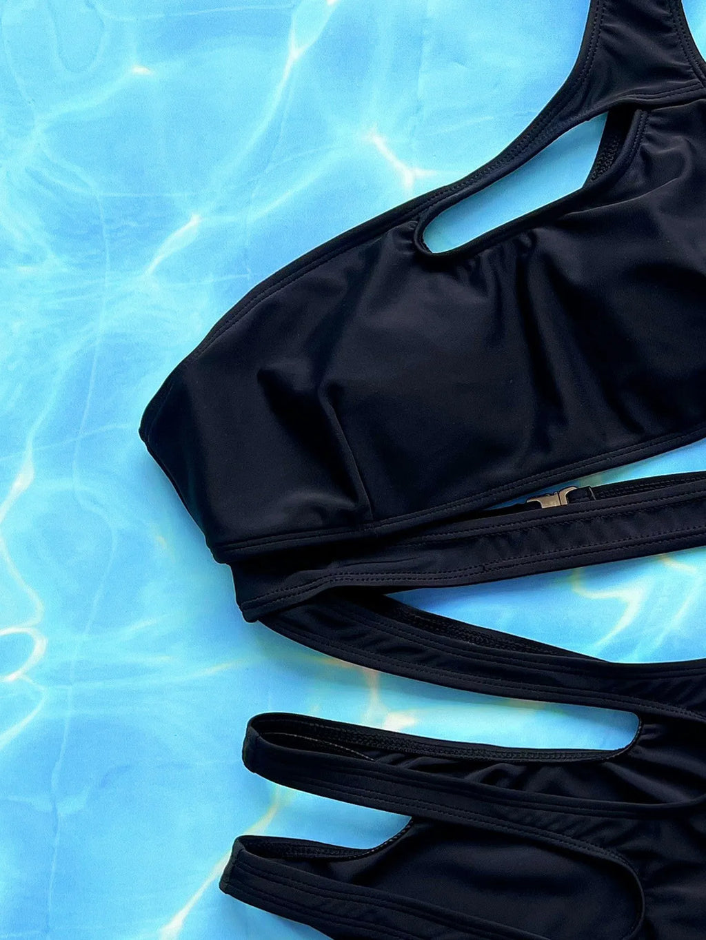 Black women's one-piece swimsuit with hollow out straps on a mannequin.