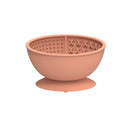 Cyan silicone dog bowl with textured slow feeder patterns and a suction cup base on a table.