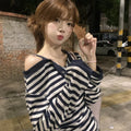 Dark blue oversized women's long-sleeved t-shirt with embroidery, stripes, and button detail on a hanger.
