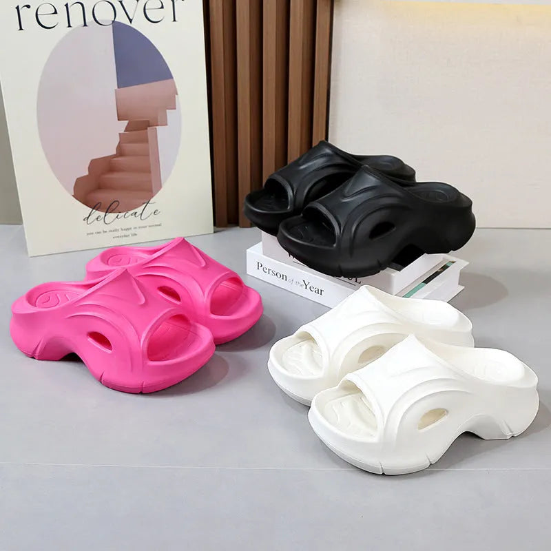 Women's thick-soled EVA slipper in rose red colour on a sandy beach background.