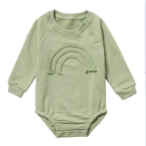 Long-sleeved waffle cotton baby romper in a neutral colour on a hanger, showing the triangular climbing front closure.