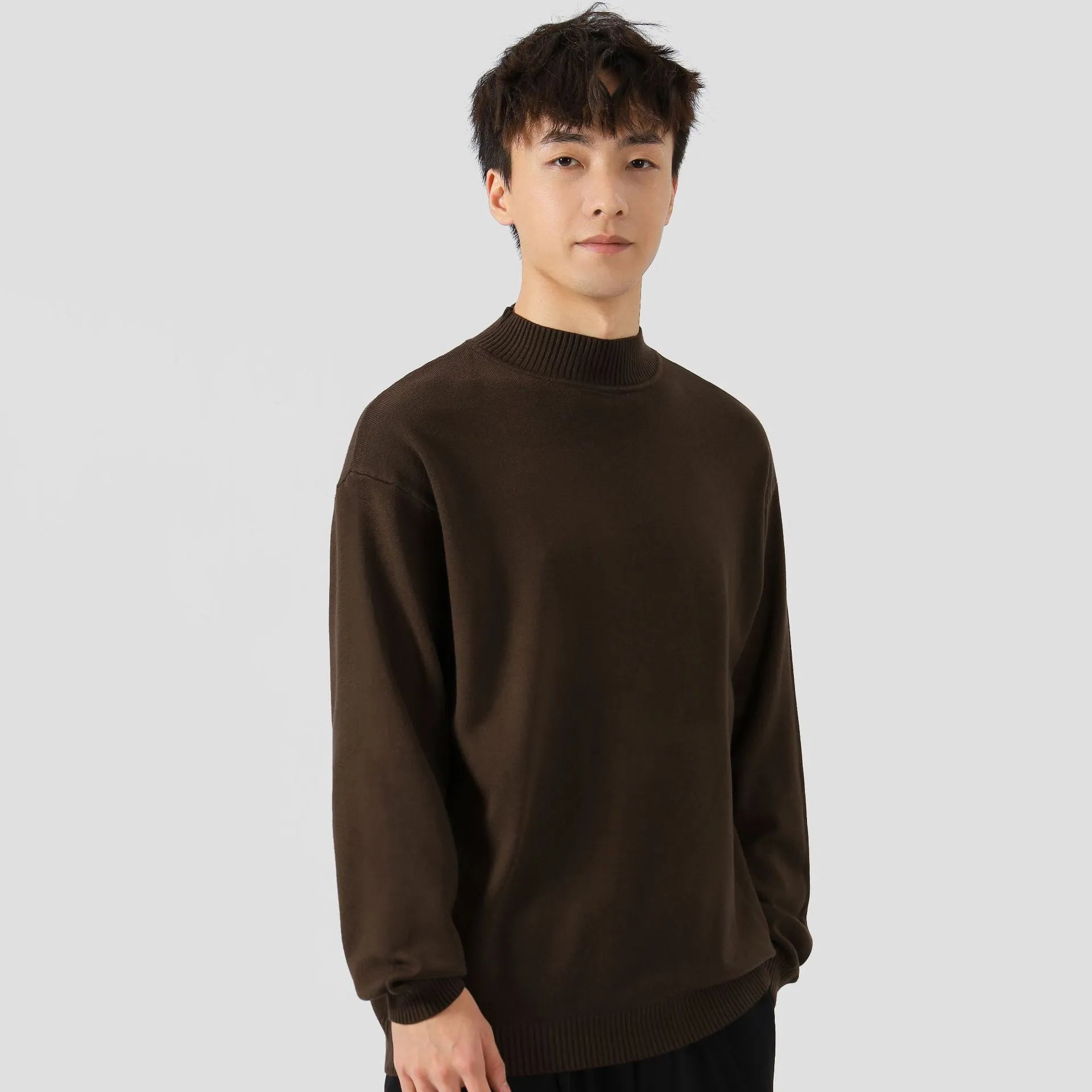 A man's loose-fitting, long-sleeve pullover sweater in a solid colour, showing a casual relaxed fit.
