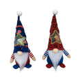 Two faceless Rudolf reindeer doll ornaments with candy bags on a festive background.