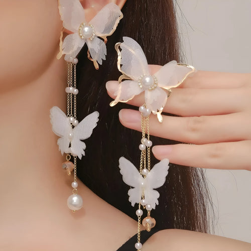 A pair of white butterfly-shaped earrings with lace, pearl, rhinestone and tassel details on a copper alloy base.