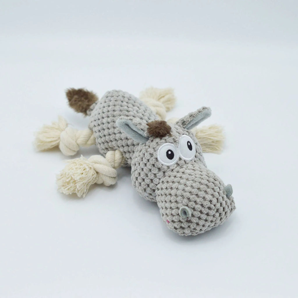 Grey plush donkey dog toy with creaking sound, showing size against a hand.