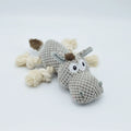 Grey plush donkey dog toy with creaking sound, showing size against a hand.