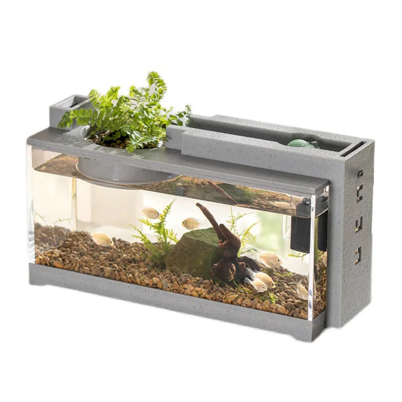 Small stone trough plastic fish tank with water pump and built-in light on a desk